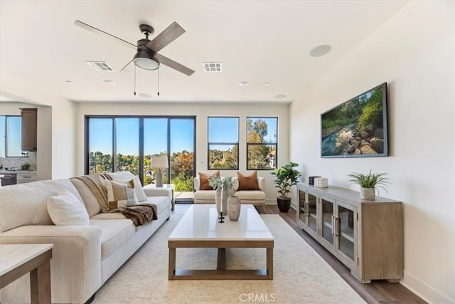 living room featuring ceiling fan and light hardwood / wood-style floors