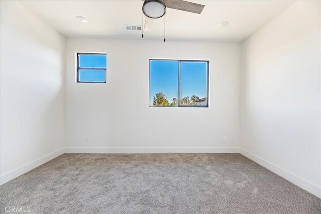 carpeted spare room with ceiling fan and a wealth of natural light