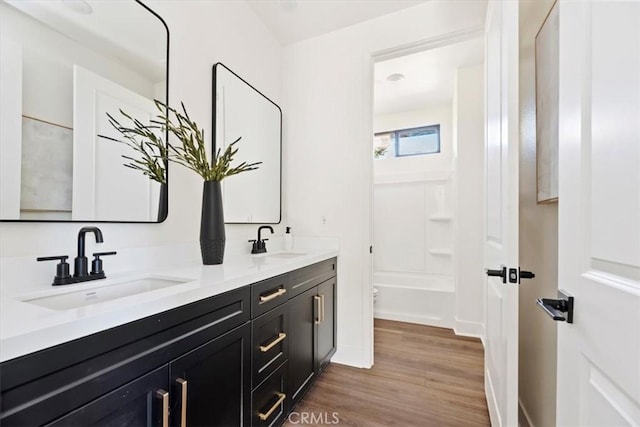 full bathroom featuring toilet, hardwood / wood-style floors, vanity, and washtub / shower combination