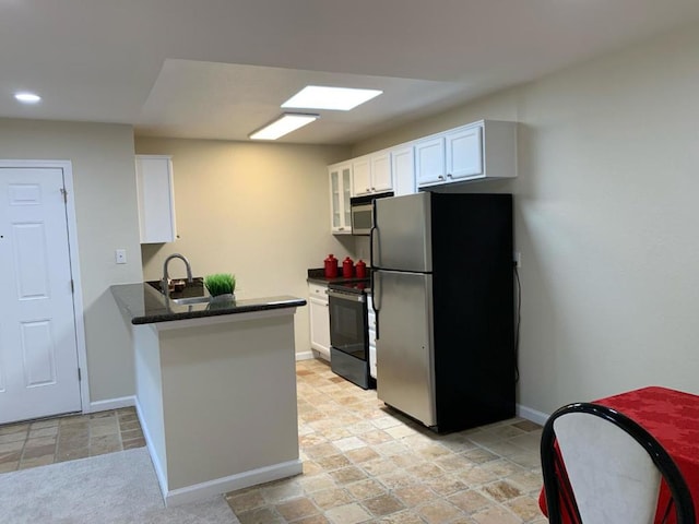 kitchen with kitchen peninsula, appliances with stainless steel finishes, sink, and white cabinetry