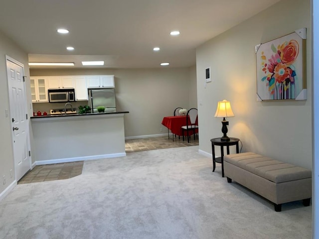 kitchen featuring light colored carpet, white cabinetry, kitchen peninsula, and stainless steel appliances