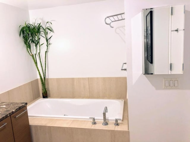 bathroom with vanity and a relaxing tiled tub