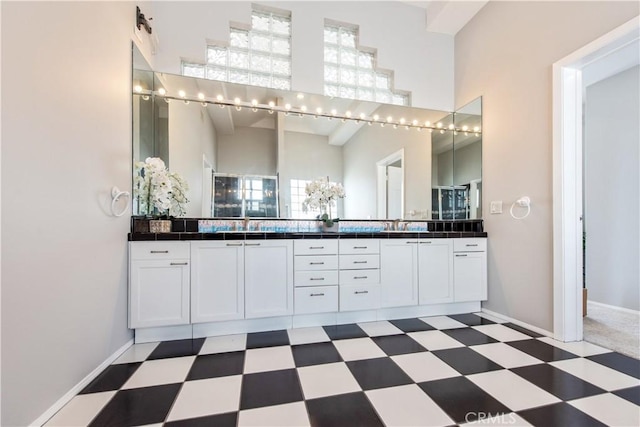 bathroom featuring a towering ceiling and vanity