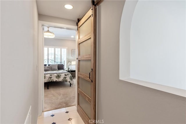 hall with light carpet and a barn door