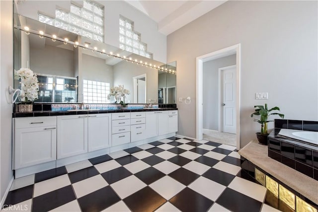 bathroom featuring a bathing tub, a high ceiling, and vanity