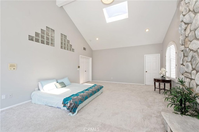 carpeted bedroom with a skylight, beam ceiling, and high vaulted ceiling