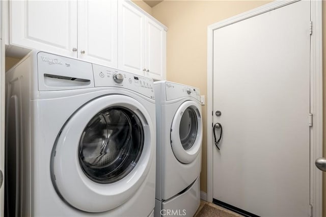 washroom featuring cabinets and washer and clothes dryer