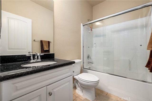 full bathroom with bath / shower combo with glass door, tile patterned floors, vanity, and toilet