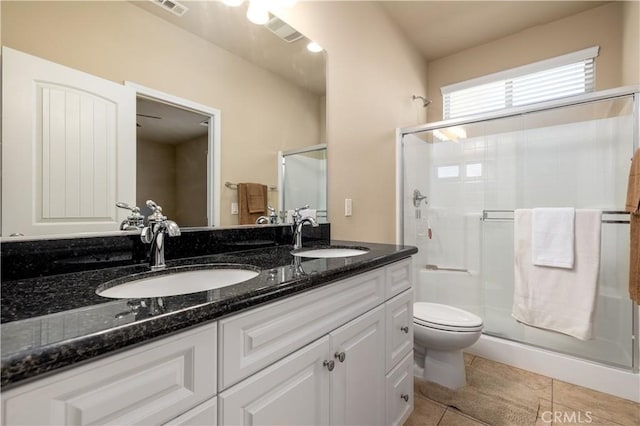 bathroom with toilet, tile patterned flooring, a shower with door, and vanity