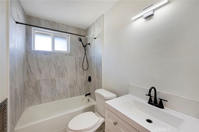 full bathroom featuring tiled shower / bath combo, vanity, and toilet