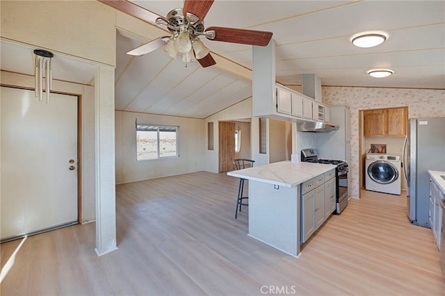 kitchen with washer / clothes dryer, light wood-type flooring, and appliances with stainless steel finishes