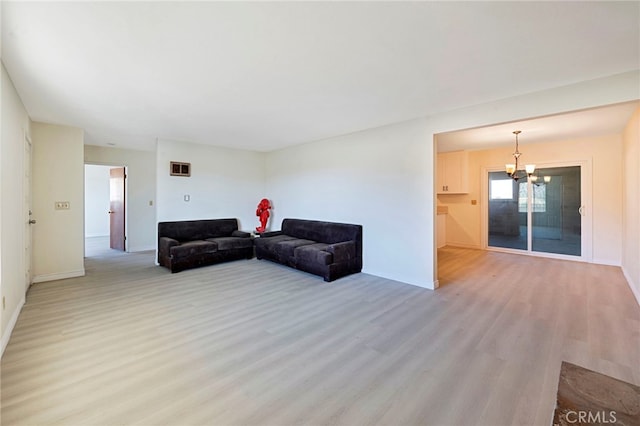 living room featuring light wood-type flooring and a notable chandelier