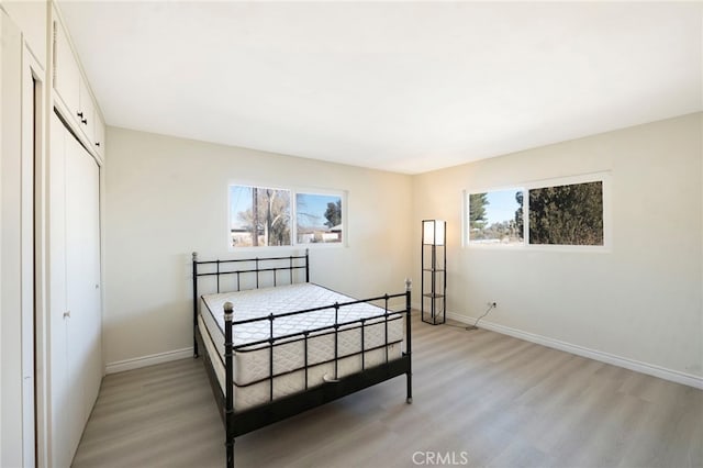 bedroom featuring light wood-type flooring and a closet