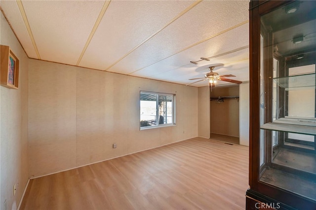 spare room with ceiling fan, hardwood / wood-style floors, and a textured ceiling