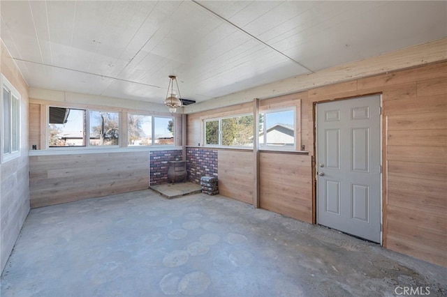 unfurnished sunroom featuring a wood stove