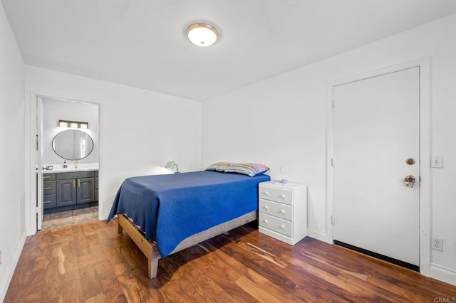 bedroom with sink, connected bathroom, and dark hardwood / wood-style floors