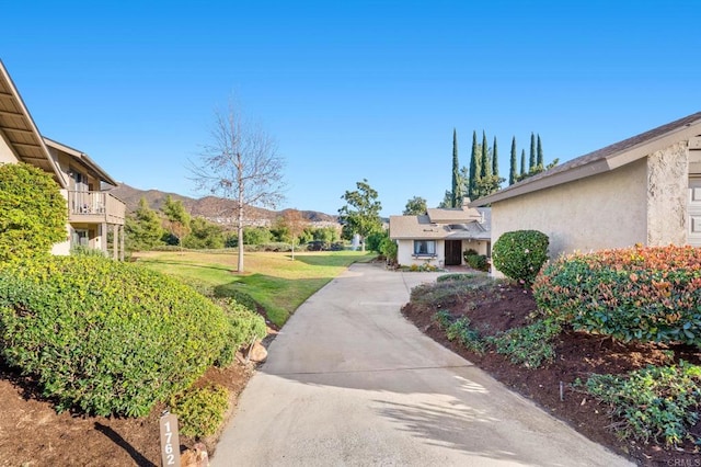 view of community with a lawn and a mountain view