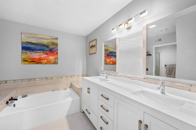 bathroom featuring tile patterned floors, a tub, and vanity