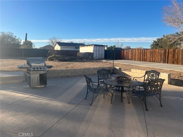 view of patio with a fire pit, grilling area, and a storage unit