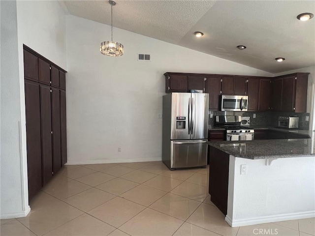 kitchen with pendant lighting, lofted ceiling, stainless steel appliances, tasteful backsplash, and kitchen peninsula