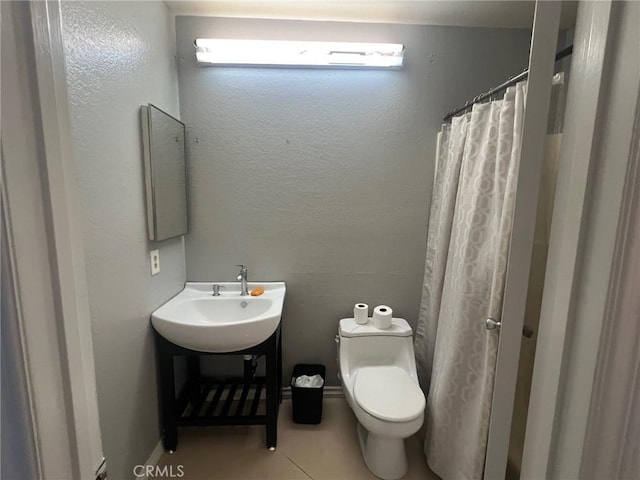 bathroom with sink, tile patterned floors, toilet, and a shower with shower curtain