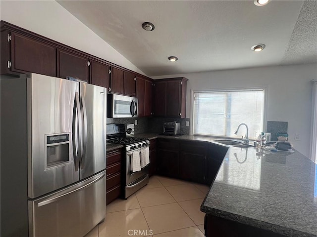 kitchen featuring appliances with stainless steel finishes, vaulted ceiling, decorative backsplash, sink, and light tile patterned flooring