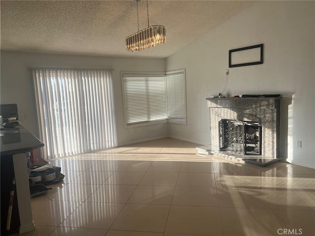 unfurnished living room with vaulted ceiling, a high end fireplace, tile patterned floors, and a textured ceiling