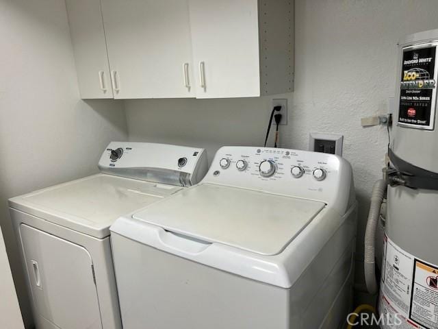 clothes washing area with washing machine and clothes dryer and cabinets