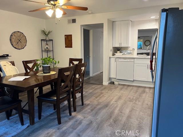 dining area featuring ceiling fan and light wood-type flooring