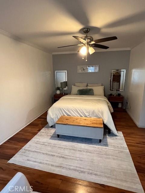 bedroom with ceiling fan, dark hardwood / wood-style floors, and crown molding