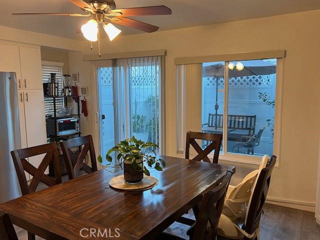 dining room with ceiling fan and dark hardwood / wood-style flooring