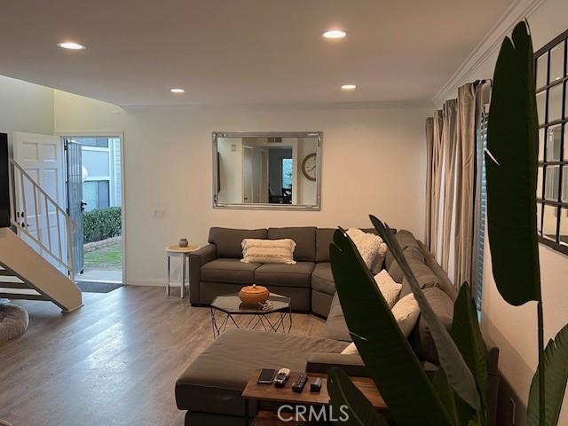 living room with crown molding and hardwood / wood-style flooring