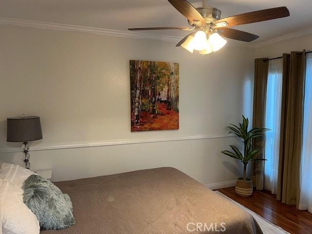 bedroom featuring ceiling fan, wood-type flooring, and crown molding