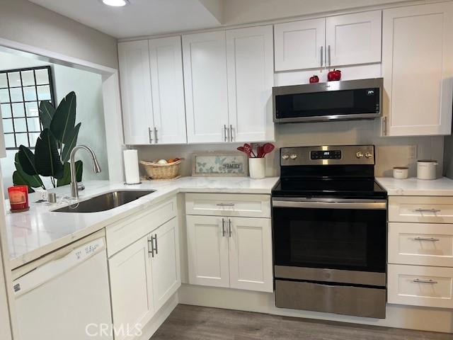 kitchen with sink, stainless steel appliances, and white cabinetry