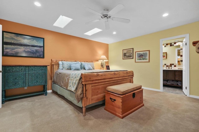 bedroom with ceiling fan, ensuite bath, carpet, and sink