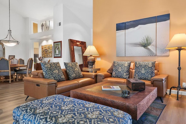 living room with a high ceiling and light hardwood / wood-style flooring