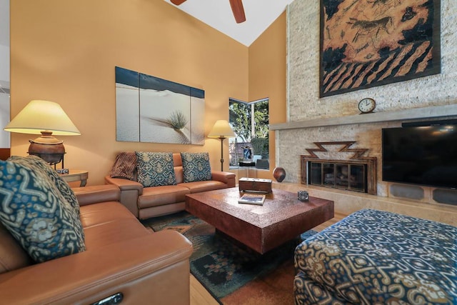 living room with ceiling fan, a fireplace, and high vaulted ceiling