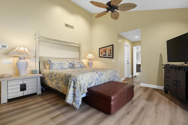 bedroom featuring ceiling fan, wood-type flooring, ensuite bathroom, and lofted ceiling