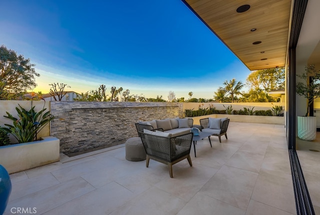 patio terrace at dusk featuring outdoor lounge area