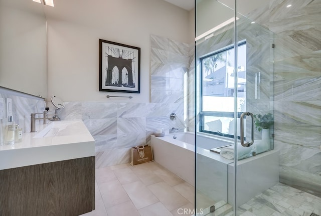 bathroom with plus walk in shower, tile patterned flooring, tile walls, and vanity