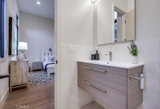 bathroom with tile walls, hardwood / wood-style floors, and vanity