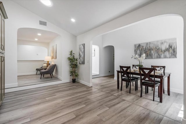 dining area featuring light hardwood / wood-style flooring and vaulted ceiling