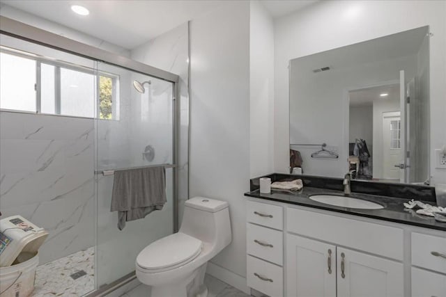 bathroom featuring a shower with shower door, toilet, and vanity