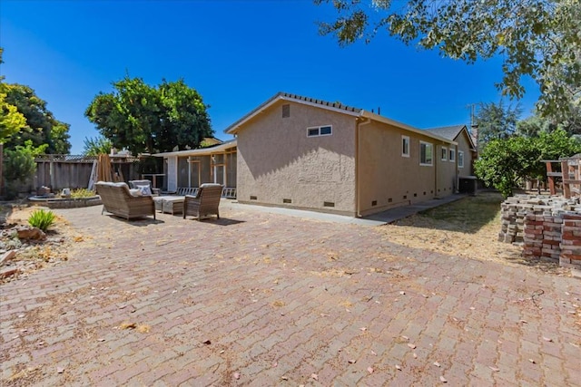 rear view of property featuring an outdoor living space, a sunroom, and a patio area