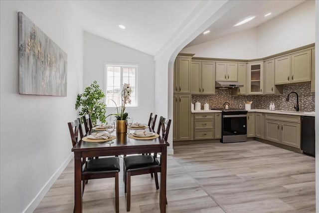 kitchen with stainless steel electric stove, dishwasher, sink, high vaulted ceiling, and decorative backsplash