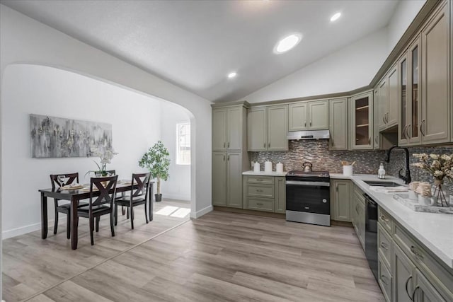 kitchen with dishwasher, decorative backsplash, stainless steel range with electric stovetop, sink, and vaulted ceiling