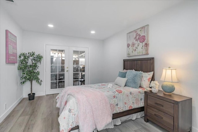 bedroom featuring access to exterior, light hardwood / wood-style flooring, and french doors