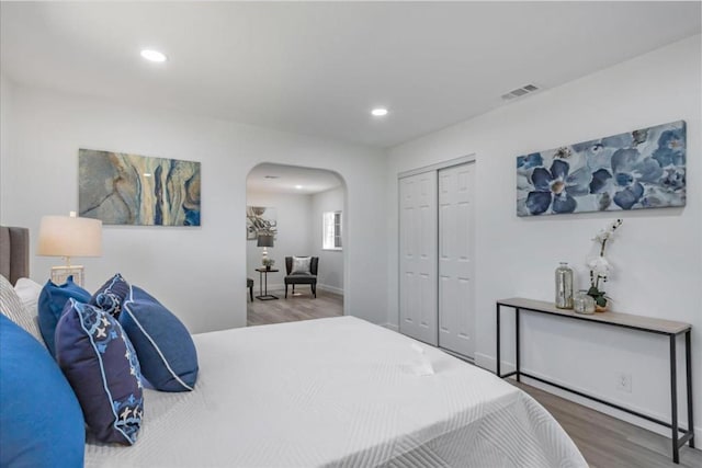 bedroom with wood-type flooring and a closet