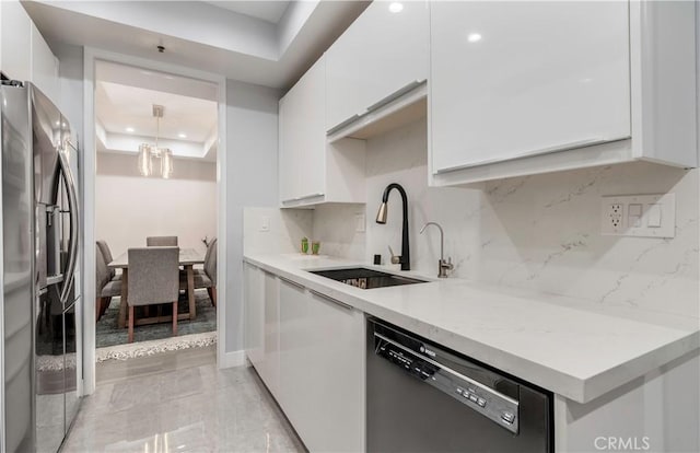 kitchen featuring dishwashing machine, a sink, white cabinets, stainless steel fridge with ice dispenser, and a raised ceiling