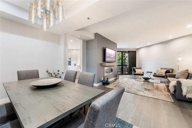 dining room featuring baseboards, a fireplace, wood finished floors, and recessed lighting